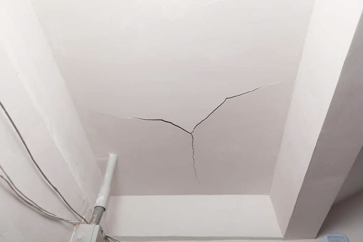 Close-up of a crack running across a false ceiling in need of repair
